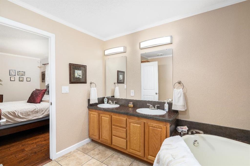 360 Rockcrest Road New Hope, TX 75071 - Photo 16 of 20 a en suite bathroom with a double vanity sink a mirror and a bathtub