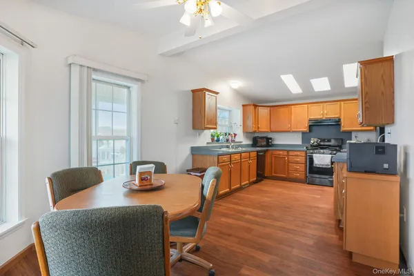 a kitchen with a table chairs refrigerator and a window