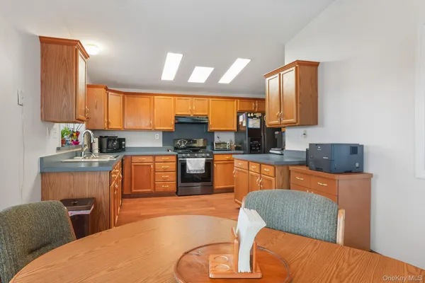 a living room with furniture kitchen view and a large window