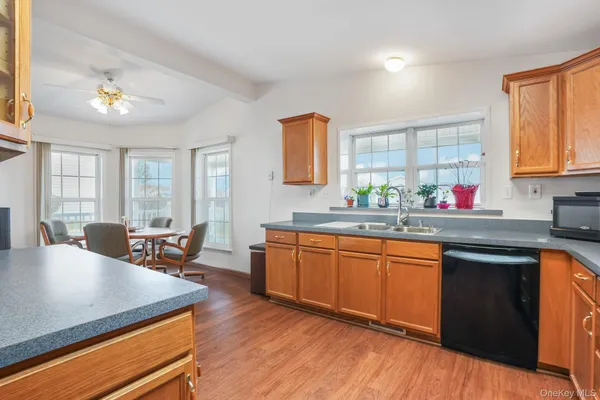 a kitchen with stainless steel appliances granite countertop wooden cabinets a stove a sink a dining table and chairs