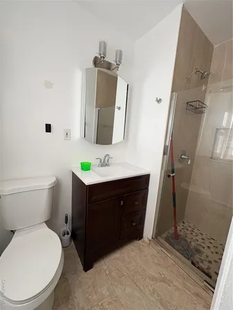 a bathroom with a sink vanity mirror and toilet