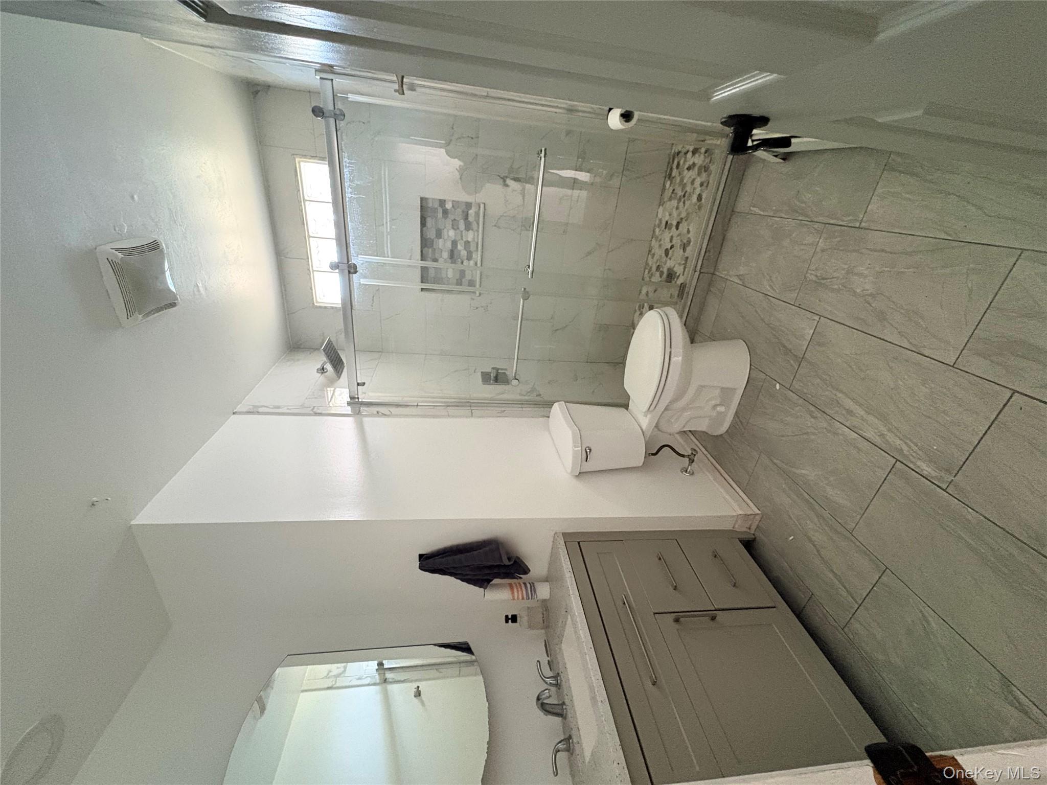77 Upper Road Middletown, NY 10940 - Photo 19 of 21 a bathroom with a granite countertop toilet a sink a mirror and shower