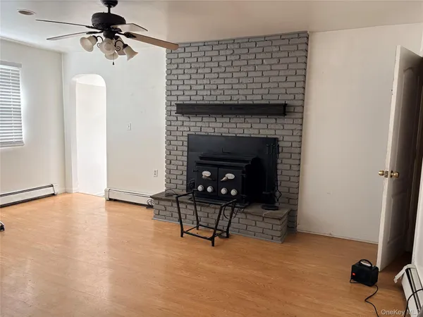 a view of an empty room with a fireplace and a window