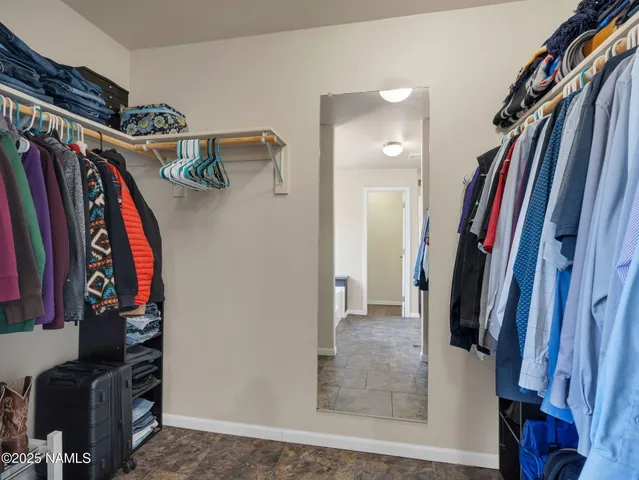 a view of walk in closet with clothes and shoes