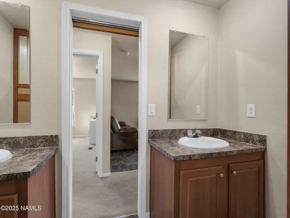 a en suite bathroom with a granite countertop sink and a mirror
