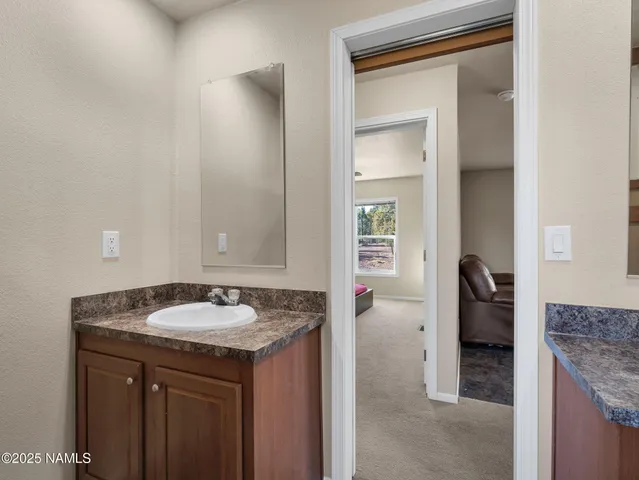 a en suite bathroom with a granite countertop sink and a mirror
