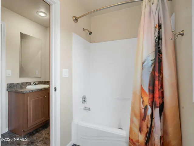 a bathroom with a granite countertop shower and a sink