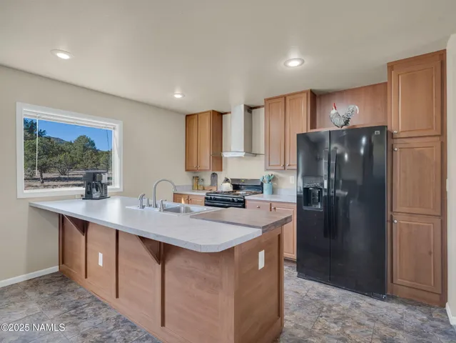 a kitchen with stainless steel appliances granite countertop a refrigerator a sink a stove a microwave and island