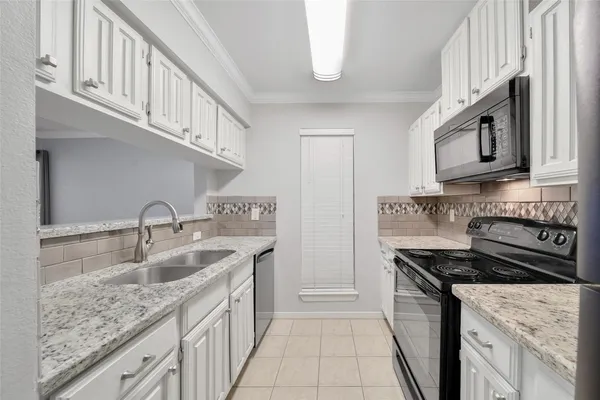 a kitchen with stainless steel appliances granite countertop a sink stove and cabinets