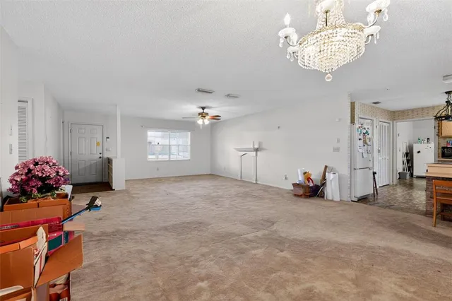 a view of a livingroom with a chandelier furniture and windows
