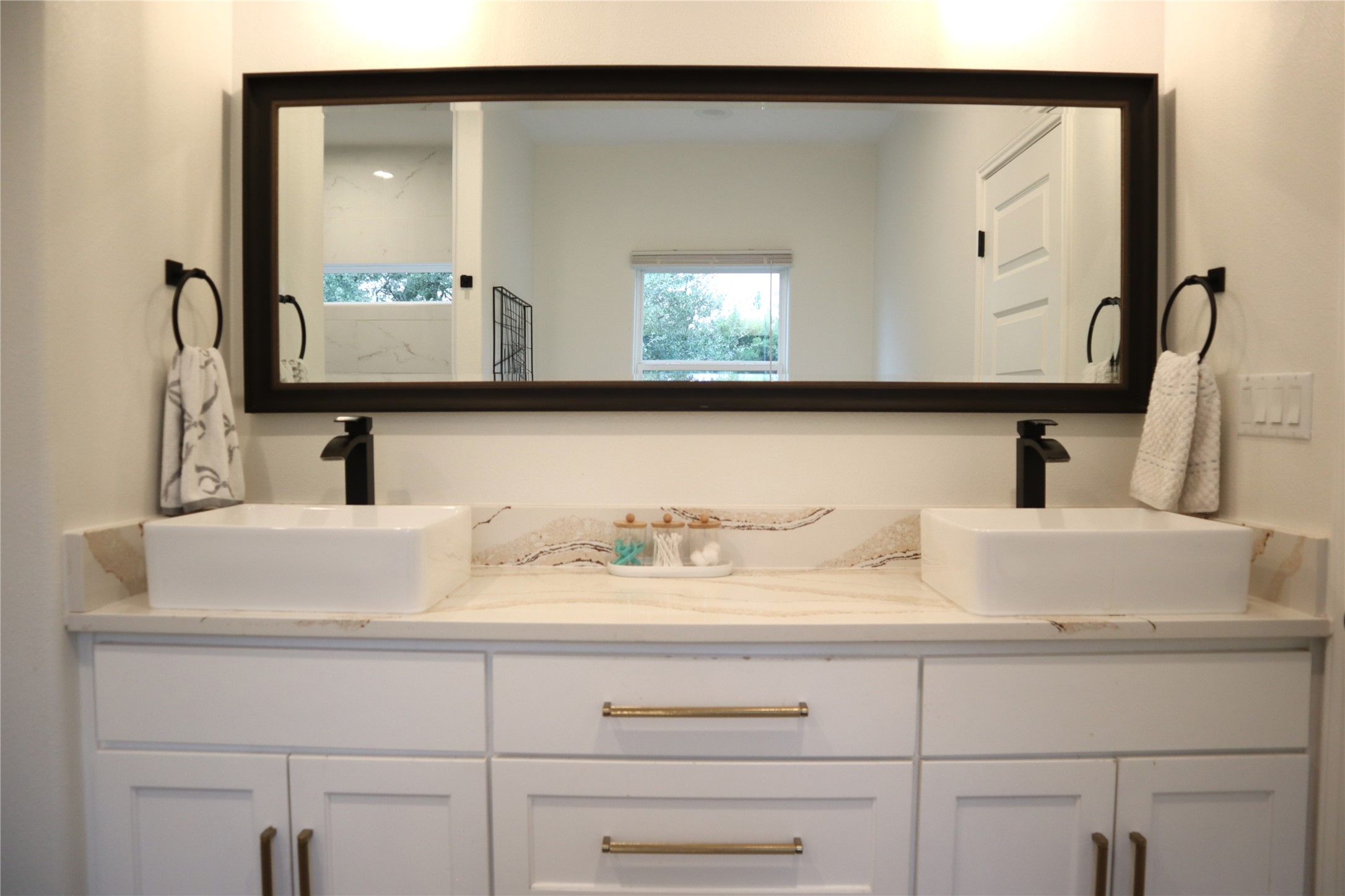 20602 Oak Ridge Lago Vista, TX 78645 - Photo 21 of 35 Dual vessel sinks pair with stone counters and modern fixtures to elevate this elegant vanity.