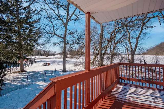 a balcony with wooden floor and trees