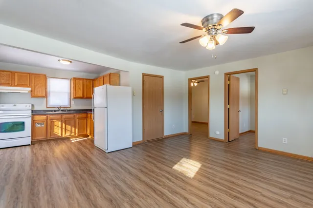 a view of a kitchen with wooden floor and a ceiling fan