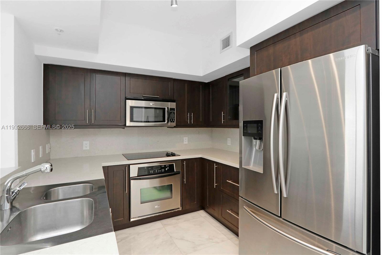 888 Douglas Road, Unit 1203 Coral Gables, FL 33134 - Photo 12 of 27 a kitchen with a refrigerator sink and microwave