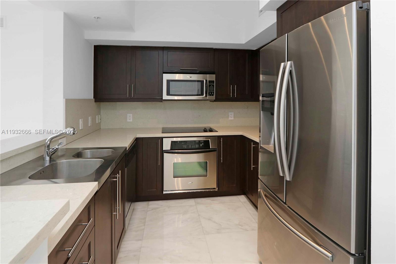 888 Douglas Road, Unit 1203 Coral Gables, FL 33134 - Photo 10 of 27 a kitchen with a refrigerator sink and microwave