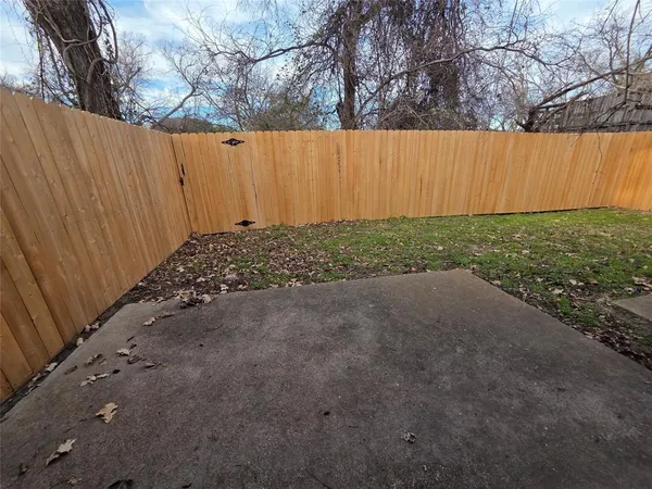 a view of a backyard with wooden fence