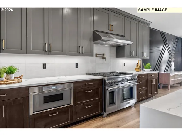 a kitchen with stainless steel appliances granite countertop a sink a stove and a refrigerator