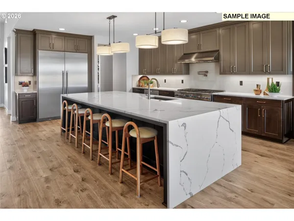 a kitchen with stainless steel appliances kitchen island granite countertop a table chairs sink and cabinets