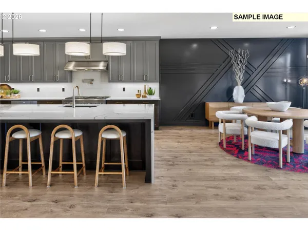 a living room with furniture kitchen view and a wooden floor