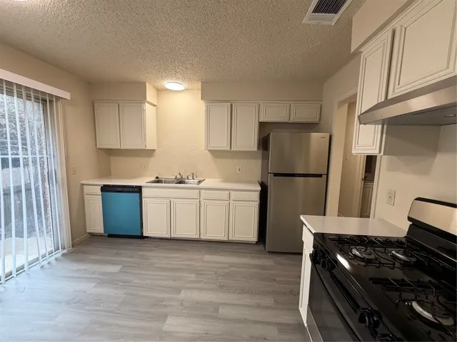 a bathroom with a toilet a sink and wooden floor