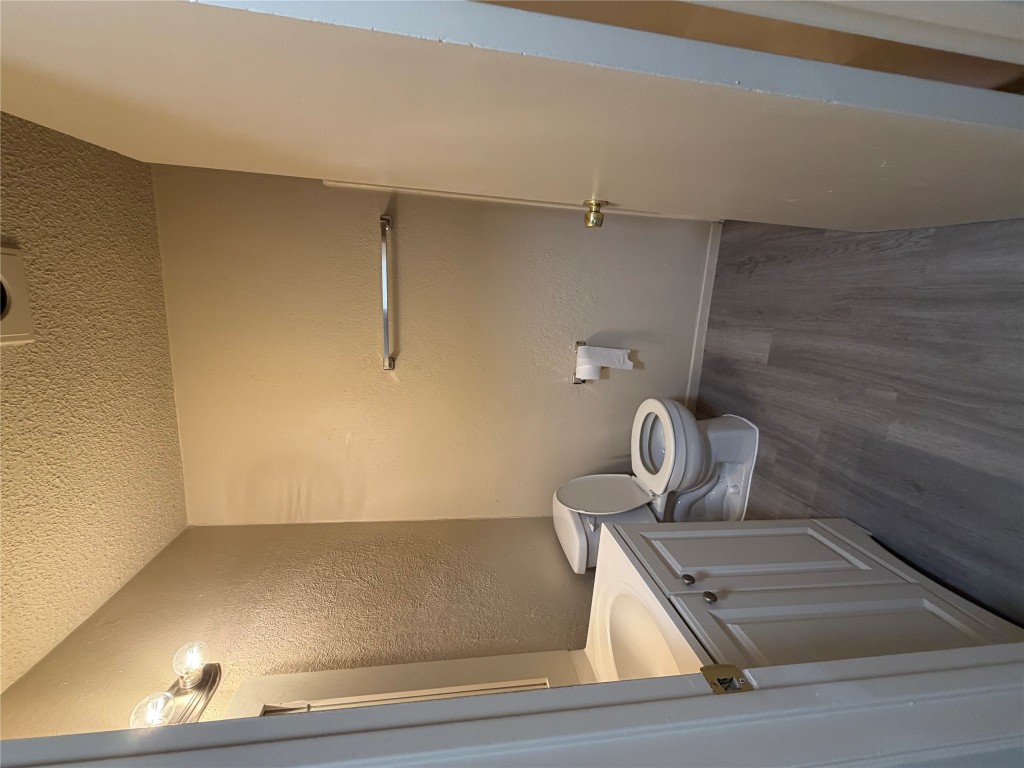 2400 Berkeley Avenue, Unit B Austin, TX 78745 - Photo 15 of 18 a bathroom with a toilet a sink and wooden floor