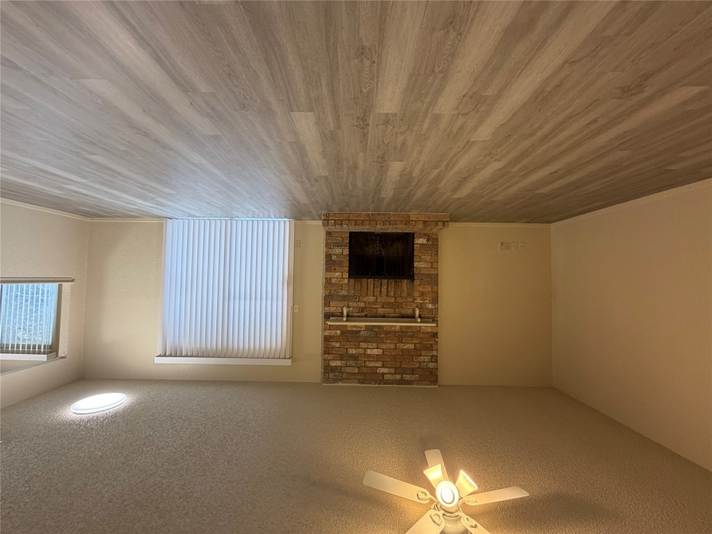 2400 Berkeley Avenue, Unit B Austin, TX 78745 - Photo 6 of 18 a view of an empty room with wooden floor and a fireplace