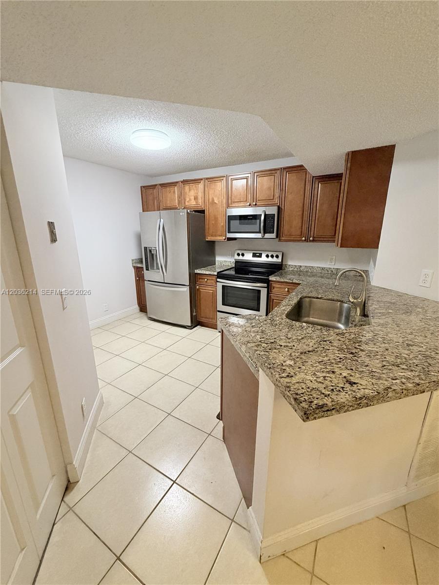 8741 Wiles Road, Unit 204 Coral Springs, FL 33067 - Photo 4 of 16 a kitchen with stainless steel appliances granite countertop a sink stove and refrigerator