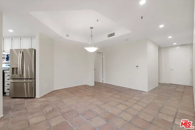a view of a kitchen with a refrigerator and a stove top oven