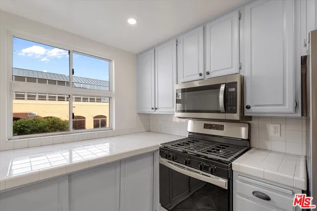 a kitchen with stainless steel appliances a stove a microwave and a sink