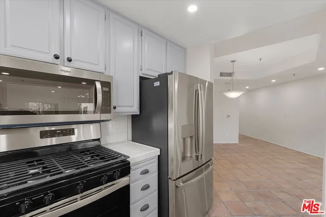 a kitchen with granite countertop a stove and a refrigerator