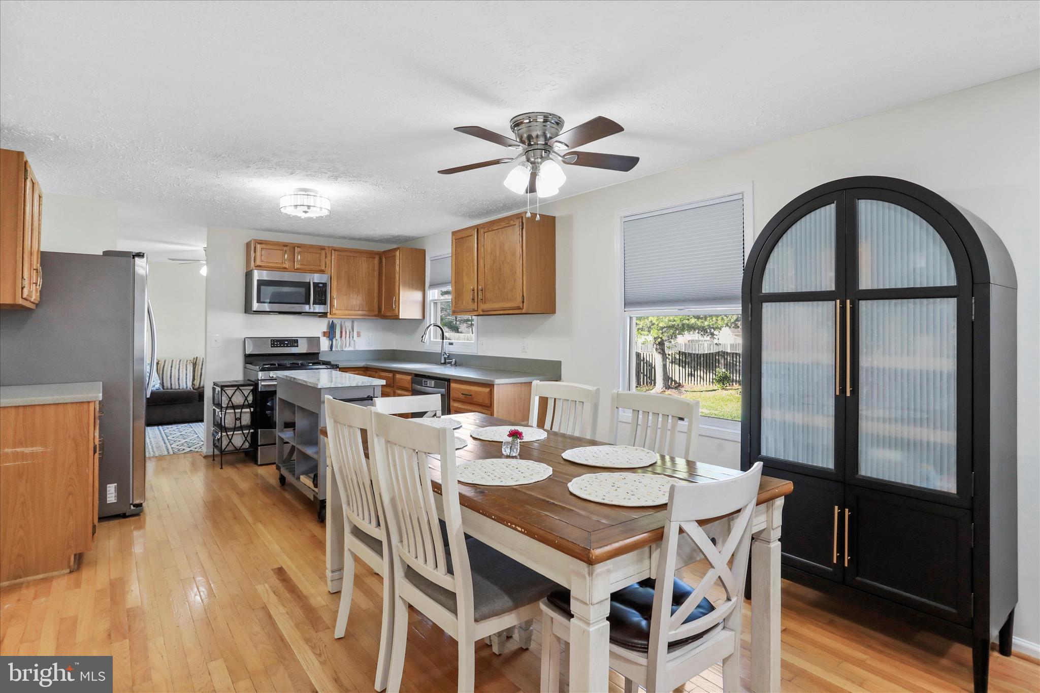 5435 Tree Line Drive Centreville, VA 20120 - Photo 12 of 51 a kitchen with stainless steel appliances granite countertop a stove a refrigerator a microwave a dining table and chairs with wooden floor