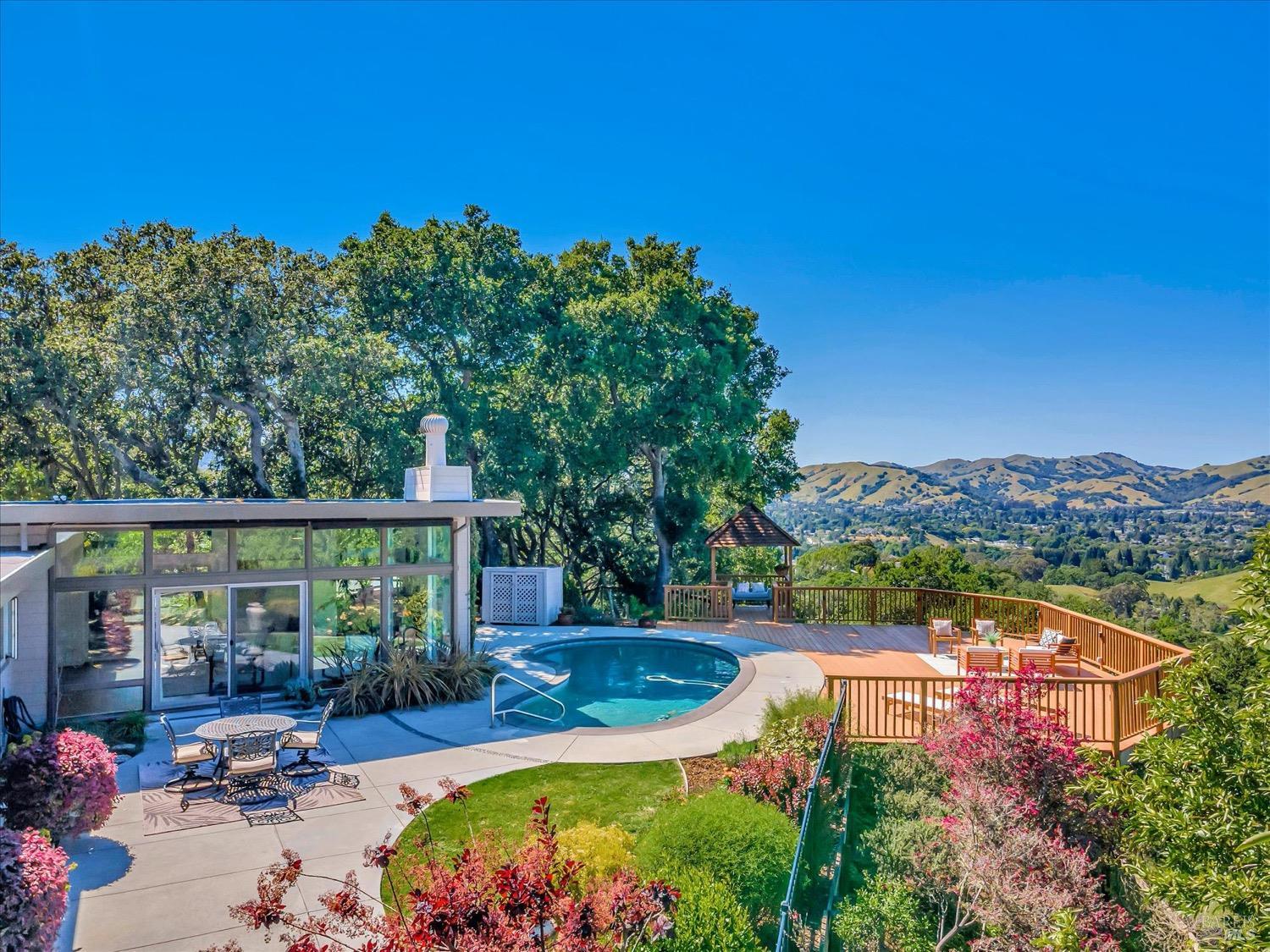 an aerial view of a house with swimming pool a yard and mountain view