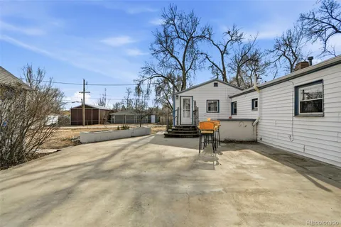 a view of a white house with a large tree and a yard