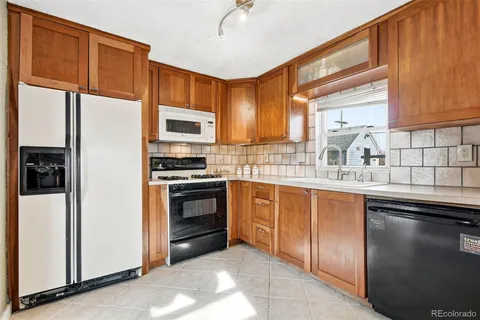 a kitchen with granite countertop stainless steel appliances and wooden cabinets