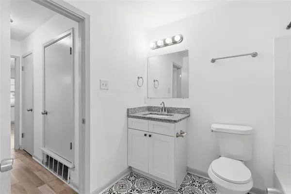 a bathroom with a toilet a sink and mirror