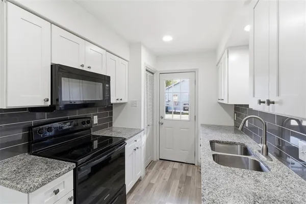 a kitchen with granite countertop a sink and a stove top oven