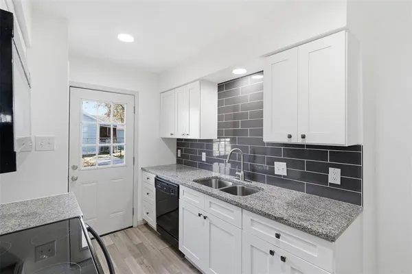 a kitchen with granite countertop a sink and cabinets