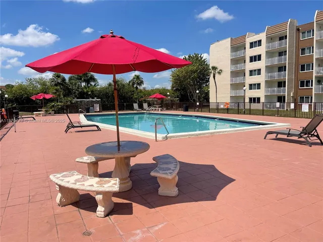 a patio with a table and chairs under an umbrella