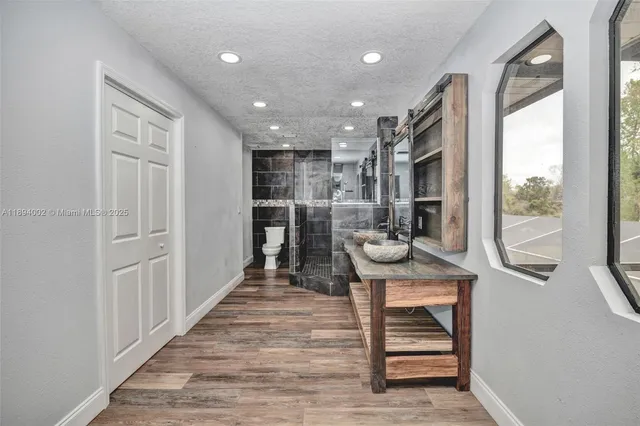 a view of a hallway with wooden floor and entryway