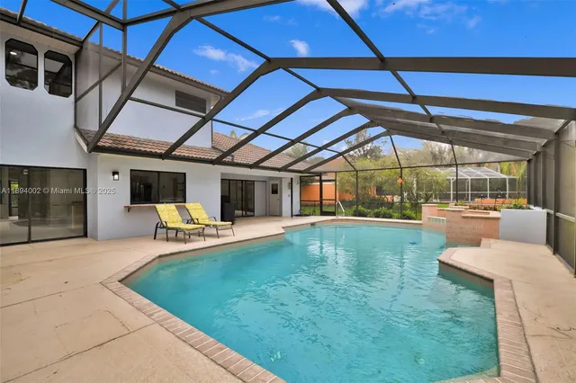 a view of a swimming pool with a patio and a yard