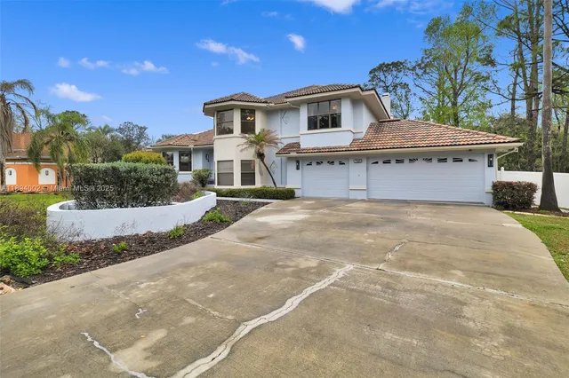 a view of a white house with a yard