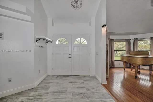 a view of a room with wooden floor mirror and windows