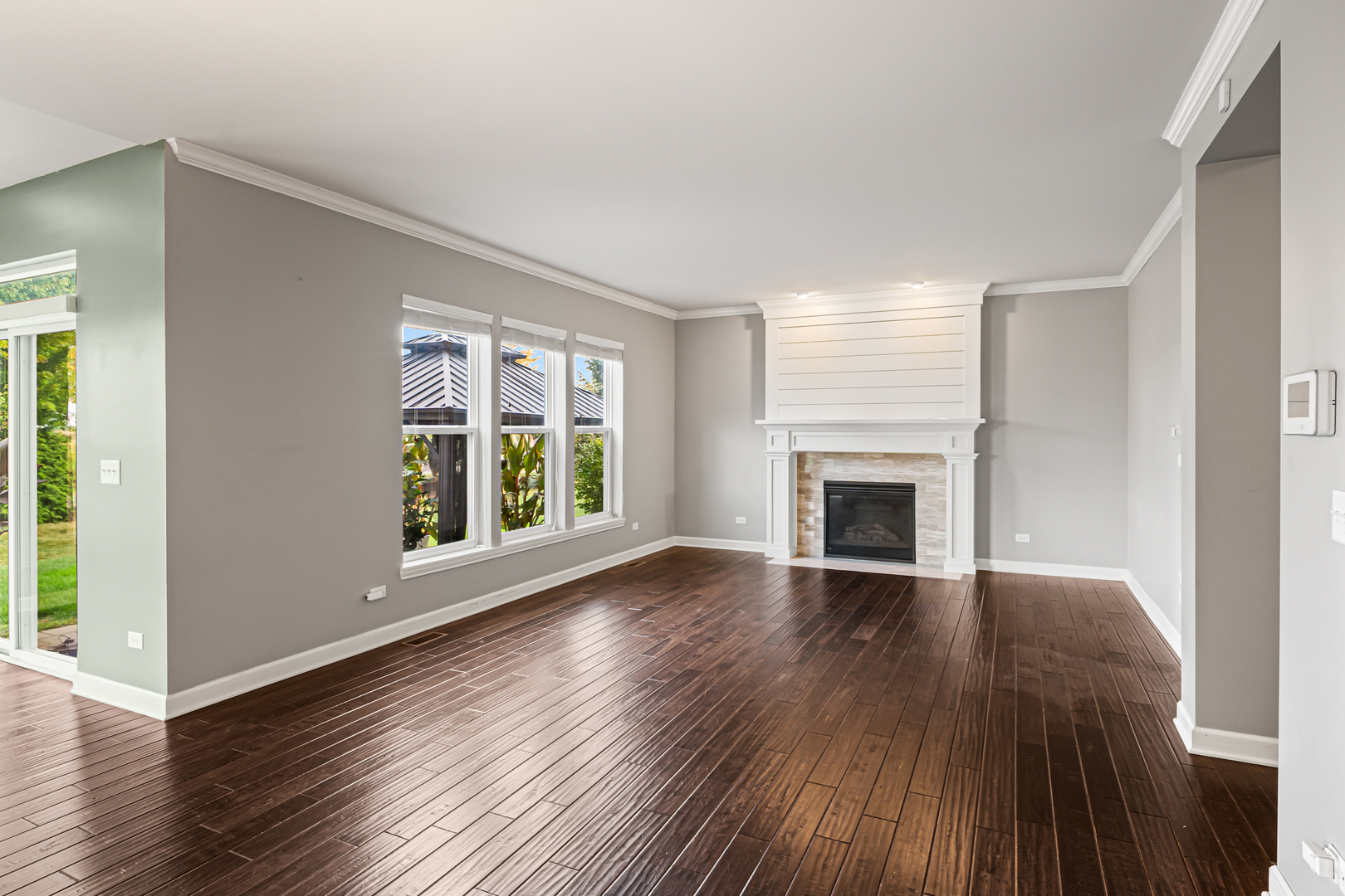 1002 Hudson Drive Joliet, IL 60431 - Photo 20 of 40 an empty room with wooden floor fireplace and windows