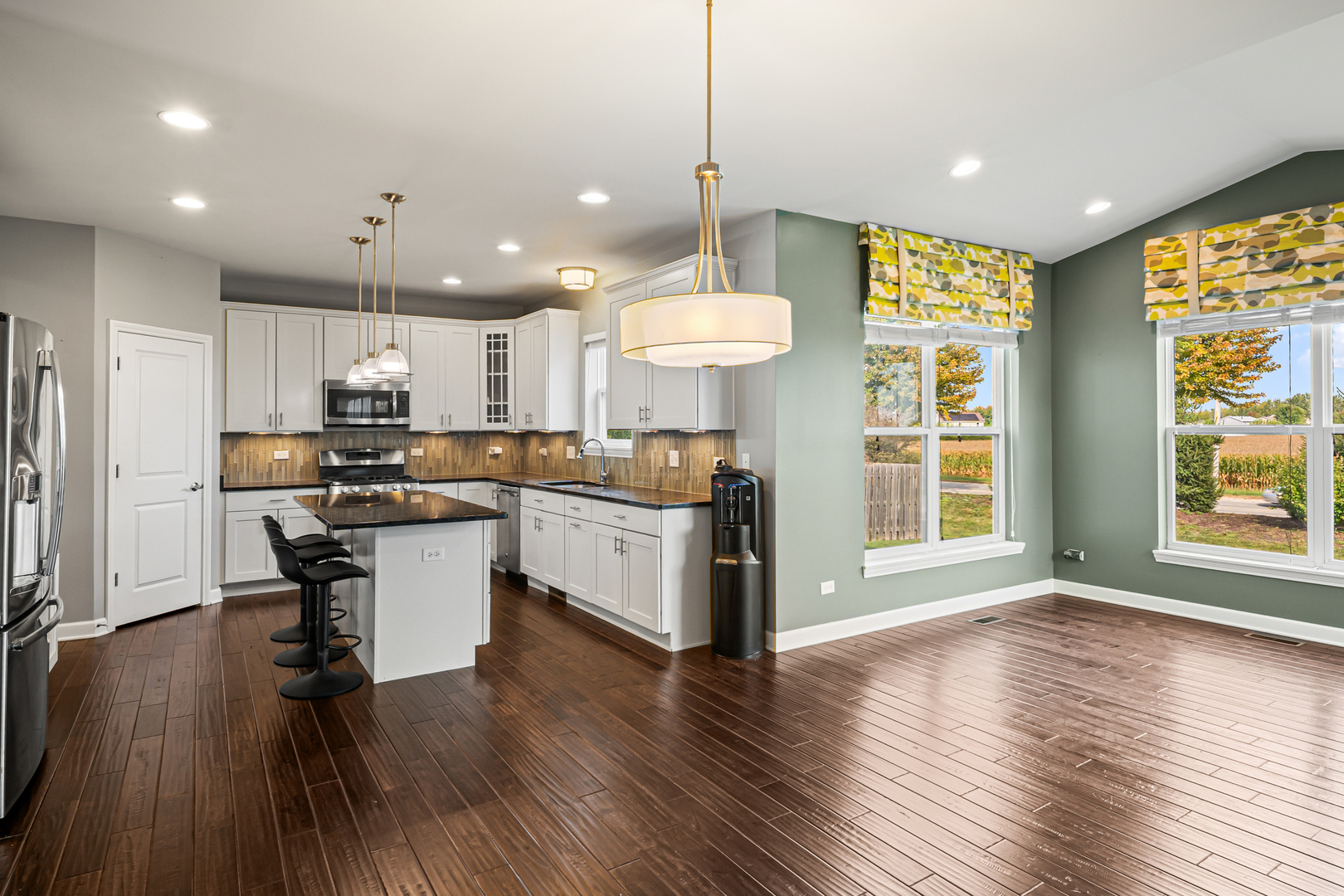 1002 Hudson Drive Joliet, IL 60431 - Photo 10 of 40 a kitchen with stainless steel appliances granite countertop wooden floors refrigerator and window