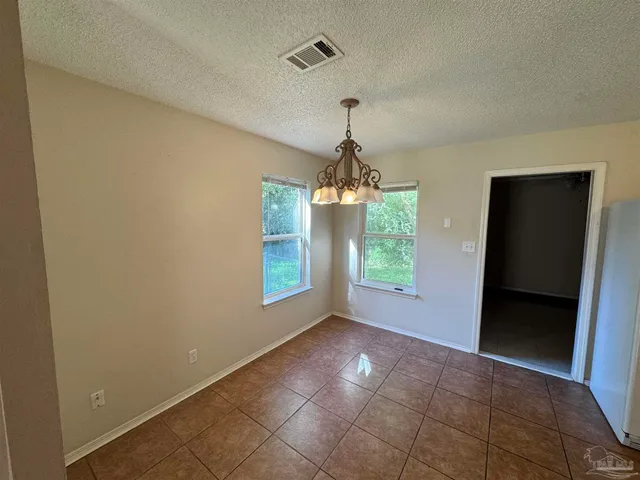 a view of empty room with windows and chandelier