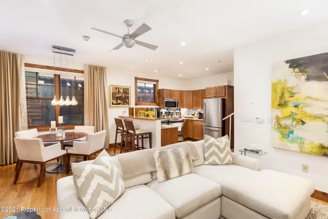 a living room with furniture kitchen view and a large window