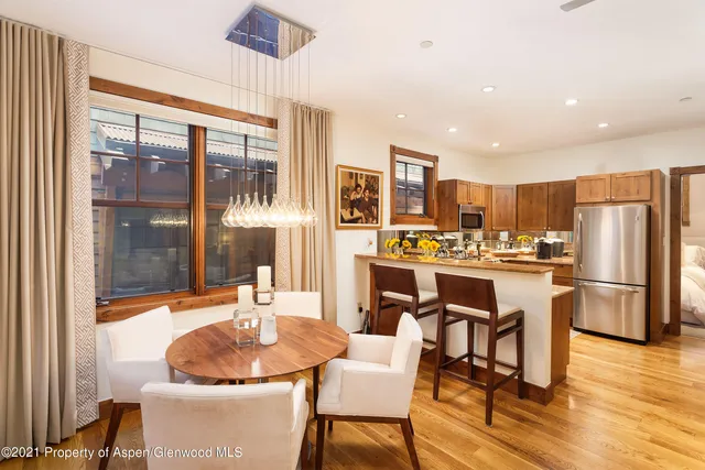 a large dining room with kitchen island stainless steel appliances furniture a large window and kitchen view