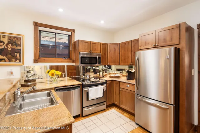 a kitchen with stainless steel appliances granite countertop a refrigerator sink and microwave