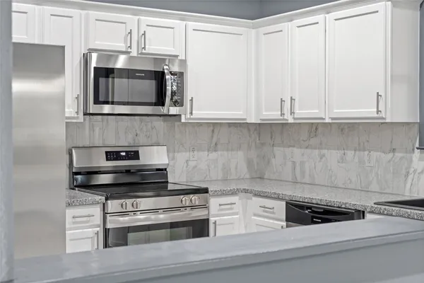 a kitchen with kitchen island a sink cabinets and window