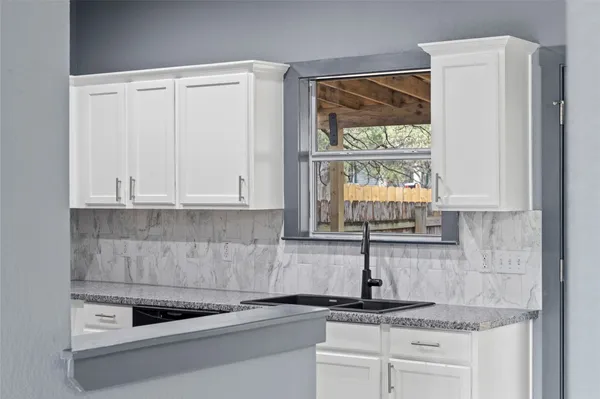 a kitchen with granite countertop a stove and a microwave